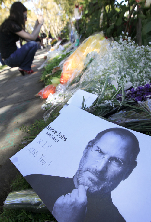 <YONHAP PHOTO-0640> A photograph of Steve Jobs, co-founder and former chief executive officer of Apple Inc., sits with flowers at a memorial outside of his home in Palo Alto, California, U.S., on Friday, Oct. 7, 2011. Jobs, who built the world's most valuable technology company by creating devices that changed how people use electronics and revolutionized the computer, music and mobile-phone industries, died on Oct. 5. He was 56. Photographer: Tony Avelar/Bloomberg/2011-10-10 06:27:17/ <저작권자 ⓒ 1980-2011 ㈜연합뉴스. 무단 전재 재배포 금지.>\r\nA photograph of Steve Jobs sits with flowers at a memorial outside of his home in Palo Alto, California.  Bloomberg