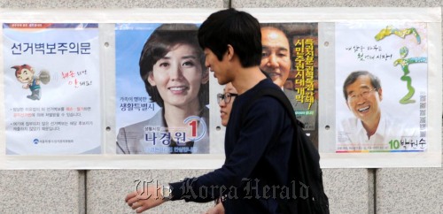 6일 서울 양천구 목동에서 시민들이 서울시장 및 양천구청장 보궐선거 벽보를 바라보고 있다.<br />안훈 기자/rosedale@heraldm.com 111016\r\nCitizens walk by posters of candidates for the Oct. 26 by-elections in Seoul on Sunday.   Ahn Hoon/ The Korea Herald\r\nCitizens walk by posters of candidates for the Oct. 26 by-elections in Seoul on Sunday.   Ahn Hoon/ The Korea Herald