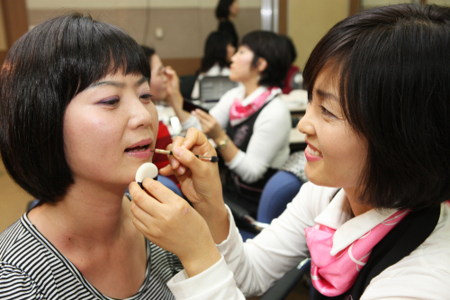 A cancer patient receives make-up from an employee of Amore Pacific at a hospital in Seoul. (Amore Pacific)