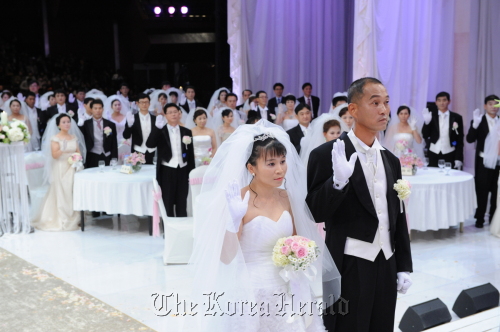 Multicultural and North Korean defector couples exchange vows during their group wedding at the KBS Hall in Seoul, Monday.  KBS\r\nMulticultural and North Korean defector couples exchange vows during their group wedding at the KBS Hall in Seoul, Monday.  KBS