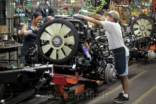 General Motors Co. employees work on the line at the company’s assembly plant in Flint, Michigan.  Bloomberg