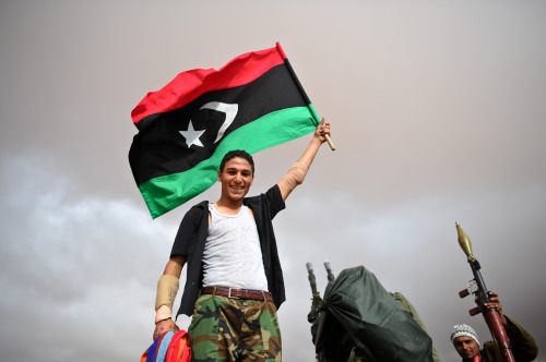 <YONHAP PHOTO-0483> (111017) -- BANI WALID, Oct. 17, 2011 (Xinhua) -- A National Transitional Council (NTC) fighter waves a flag outside a front line hospital in the suburbs of Bani Walid, Libya, Oct. 17, 2011. NTC fighters have controlled 90 percent area of Bani Walid, military spokesman Ahmed Bani said Monday. (Xinhua/Li Muzi)/2011-10-18 08:15:16/ <저작권자 ⓒ 1980-2011 ㈜연합뉴스. 무단 전재 재배포 금지.>\r\nA Libyan fighter waves a flag outside a frontline hospital in the suburbs of Bani Walid, Libya on Monday. Xinhua-Yonhap News