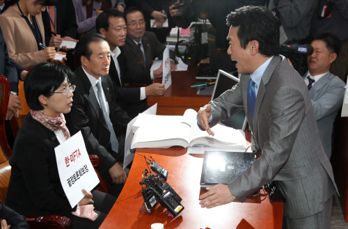<YONHAP PHOTO-1488> 외통위 野점거 파행, '비켜요! 안돼요!' (서울=연합뉴스) 전수영 기자 = 민주당과 민주노동당 등 야당 의원들이 한미FTA(자유무역협정) 비준안 강행처리 반대를 주장하며 국회 외교통상통일위원회 의장석을 점거한 18일 오후 남경필 외통위원장이 점거된 위원장석 앞에서 민주노동당 이정희 대표에게 자리에서 나와 줄것을 요구하고 있다. 2011.10.18 swimer@yna.co.kr/2011-10-18 16:08:16/ <저작권자 ⓒ 1980-2011 ㈜연합뉴스. 무단 전재 재배포 금지.>\r\nGrand National Party Rep. Nam Kyung-pil (right), chairman of the parliamentary committee on foreign affairs, trade and unification, demands Democratic Labor Party leader Lee Jeong-hee vacate his seat at the committee session Tuesday. Opposition lawmakers boycotted the committee meeting as the GNP sought to vote on the Korea-U.S. FTA bill.    Yonhap News