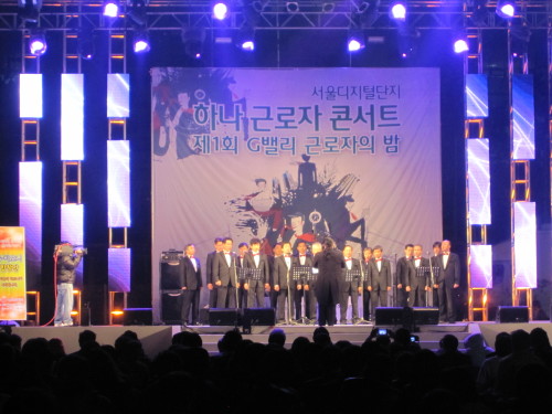 한국산업단지공단(이사장 조 석) 서울지역본부와 중소기업중앙회, 하나은행은 지난 19일 서울디지털단지운동장에서 ‘제1회 G밸리 근로자의 밤’을 개최했다. 디지털단지 최초로 열린 이날 행사에서는 근로자 노래경연대회, 인기가수 축하공연 등이 진행됐다. 입주기업 대표들로 구성된 CEO합창단 ‘G-하모니‘가 무대에서 노래를 부르고 있다