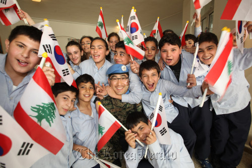 Army Chaplain Capt. Kim Soon-kyu of the Dongmyeong unit in Lebanon poses for a photo with local students on his visit to a school in March for an “Inviting Korea” event to promote Korean culture. JCS