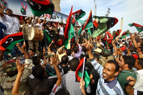 Libyan people celebrate the death of fallen Libyan leader Moammar Gadhafi in Tripoli on Thursday.      (Xinhua-Yonhap News)