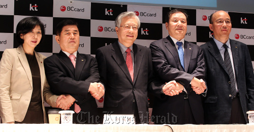 KT Corp. chairman Lee Suk-chae (center) and BC Card CEO Lee Jong-ho (second from right) pledge to converge information telecommunications and finance services at a meeting in downtown Seoul on Monday. Yonhap News