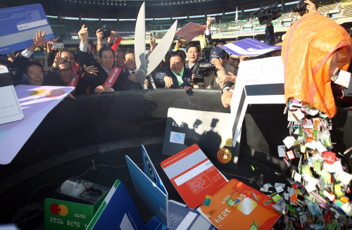 Restaurant owners throw away credit cards in protest against high transaction fees in Seoul on Oct. 18. (Yonhap News)