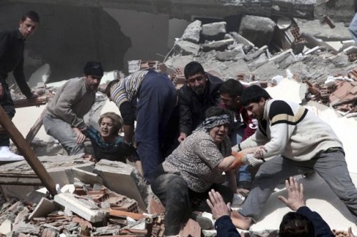 Rescue workers try to save people trapped under debris after an earthquake in a village near the eastern Turkish city of Van on Sunday. (AP)