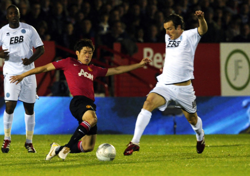 <YONHAP PHOTO-0204> Aldershot Town's Danny Hylton, right, is tackled by Manchester United''s Ji-Sung Park during their English League Cup soccer match at the EBB stadium, Aldershot, England Tuesday, Oct. 25, 2011. (AP Photo/Tom Hevezi)/2011-10-26 05:55:59/ <저작권자 ⓒ 1980-2011 ㈜연합뉴스. 무단 전재 재배포 금지.>
Manchester United’s Park Ji-sung (center) and Aldershot Town’s Danny Hylton vie for the ball.  AP-Yonhap News