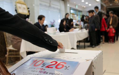 A woman casts a vote at a poll in Seoul. Yonhap