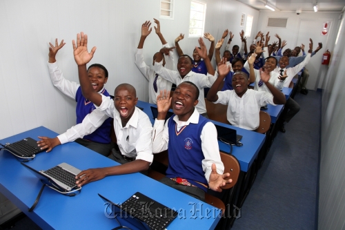 Students gesture at the digitalized mobile classroom in Boksburg, South Africa.  Samsung Electronics
