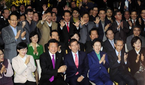 Members of the main opposition Democratic Party rejoice at independent candidate Park Won-soon’s campaign office in Seoul on Wednesday as the exit poll result shows him leading the race.  (Yonhap News)