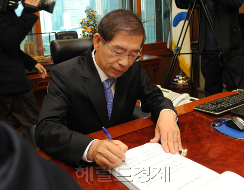 박원순 신임 서울시장이 27일 오전 서울 중구 서소문로 서울시청으로 첫 출근한 가운데 집무실에서 사무인계 인수서에 서명하며 첫 업무를 보고 있다. 사진공동취재단
New Seoul Mayor Park Won-soon begins his official work at his office in central Seoul on Thursday.  Joint Press Corps
New Seoul Mayor Park Won-soon begins his official work at his office in central Seoul on Thursday.  Joint Press Corps