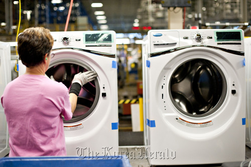 An employee installs a bellow to a front-load Whirlpool Corp. washing machine at the company’s operations plant in Clyde, Ohio.  Bloomberg