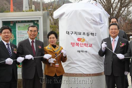 Chief of SK Group’s social enterprise project Shin Hun-cheol (second from left) takes part in the opening ceremony of an elementary school for the underprivileged children in Daegu in March.     SK Group