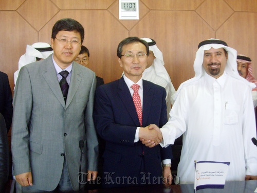 Daelim Industrial Co.’s chief of industrial plant operations Kim Yun (center) shakes hands with Saudi Arabia’s Deputy Minister for Electricity Saleh Alawji (right) after signing the contract in Riyadh on Saturday.     Daelim Industrial