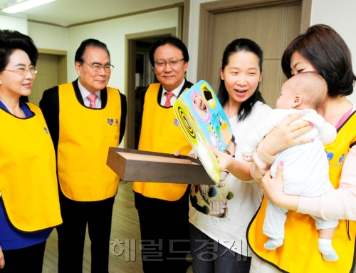 박근희(왼쪽에서 세번째) 사장이 이길여 가천대 총장, 이어령 전 문화부 장관(왼쪽부터) 등과 함께 엄마 품에 안긴 갓난 아이를 지긋이 바라보며 흐뭇해 하고 있다.