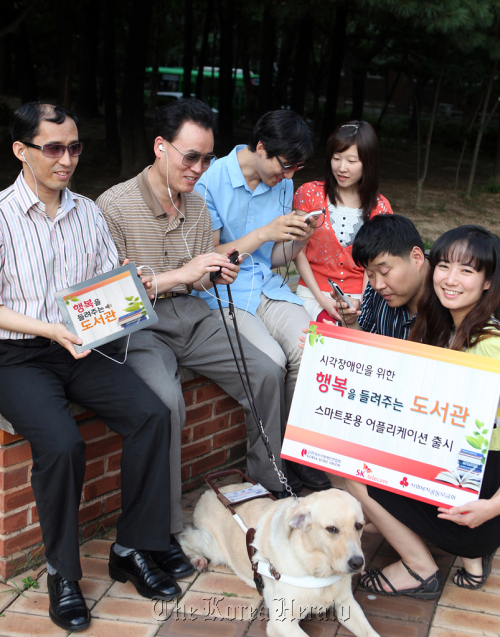 Visually impaired people use the book-reading services of the app “Library that Reads Happiness.”    SK Telecom