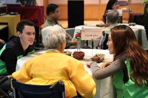Expat volunteers help an elderly Seoul resident at a senior’s center in Hongik-dong on Friday.      Seoul Global Center