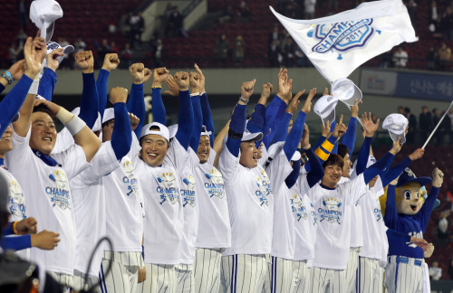 <YONHAP PHOTO-1890> <2011 KS> '만세' (서울=연합뉴스) 배정현 기자 = 31일 오후 서울 잠실야구장에서 열린 2011 프로야구 한국시리즈 5차전 SK 와이번즈와 삼성 라이온즈의 경기. 1-0으로 승리한 삼성 선수들이 시상대에 올라 두 손을 들며 기뻐하고 있다. 2011.10.31 doobigi@yna.co.kr/2011-10-31 21:37:01/ <저작권자 ⓒ 1980-2011 ㈜연합뉴스. 무단 전재 재배포 금지.>
The Samsung Lions celebrate after winning the Korean Series title.  Yonhap News