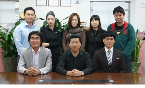 우진앤플래닛 이성구 대표를 비롯해 직원들이 기념촬영을 하고 있다. 이 대표는 사진을 찍으면서 공장에 근무하는 직원들과 함께하지 못한 것에 아쉬움을 표했다.