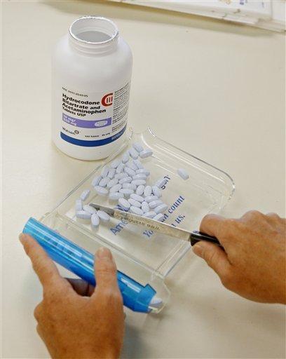 A pharmacy technician poses for a picture with hydrocodone tablets
at the Oklahoma Hospital Discount Pharmacy in Edmond. (AP)