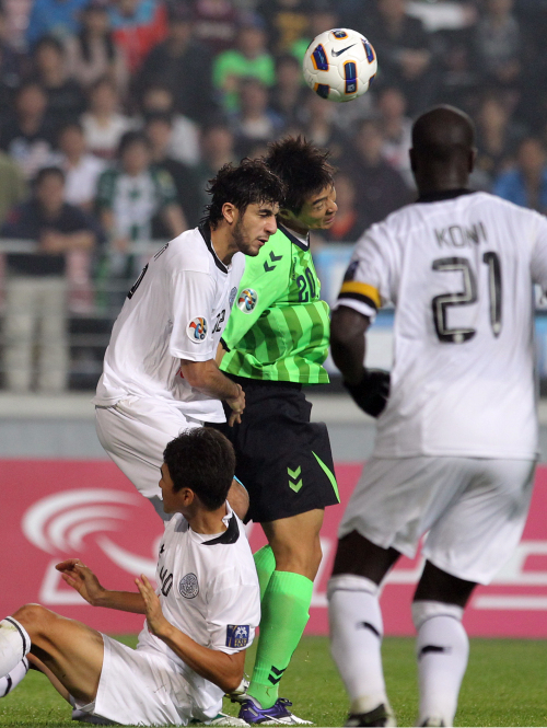 <YONHAP PHOTO-0990> AFC 결승 전북-알사드 (전주=연합뉴스) 최영수 기자 = 5일 전주월드컵경기장에서 벌어진 아시아챔피언스컵 축구 결승에서 전북현대 이동국이 알사드 수비와 헤딩볼을 다투고 있다. 2011.11.5 kan@yna.co.kr/2011-11-05 22:23:55/ <저작권자 ⓒ 1980-2011 ㈜연합뉴스. 무단 전재 재배포 금지.>
Jeonbuk’s Lee Dong-gook (center) challenges for the ball against Al Sadd defenders.  Yonhap News