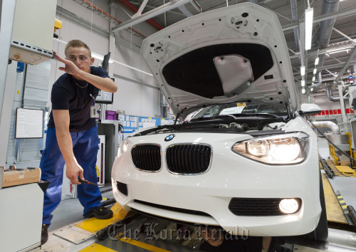 An employee makes final checks to a BMW 1-Series automobile during the last stages of manufacture at the BMW factory in Regensburg, Germany. Bloomberg