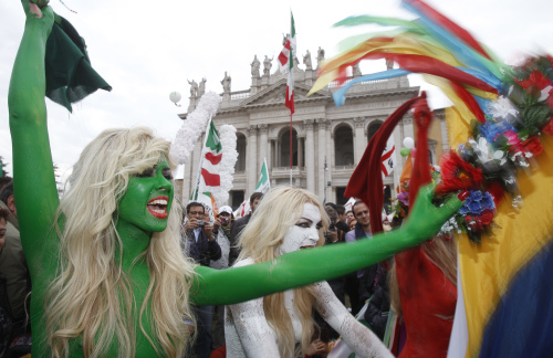 Ukrainian women's rights group Femen, painted in colors of the Italian flag, shout slogans against Italian Premier Sivlio Berlusconi during a demonstration staged by the Italian Democratic party in Rome Saturday. (AP-Yonhap News)