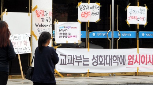 <YONHAP PHOTO-1040> "성화대 정상화하라" (강진=연합뉴스) 형민우 기자 = 전남 순천의 4년제 대학인 명신대와 강진의 전문대학인 성화대학의 퇴출이 확정된 가운데 7일 강진 성화대학 본부 입구에 퇴출 반대와 학교 정상화를 요구하는 현수막과 피켓이 나불었다. 교육과학기술부는 부정 비리가 감사에서 적발돼 폐쇄 방침을 내렸으며 두 대학 측은 이에 반발 행정소송을 제기할 방침이어서 당분간 논란이 계속될 것으로 보인다. 2011.11.7 minu21@yna.co.kr/2011-11-07 14:13:06/ <저작권자 ⓒ 1980-2011 ㈜연합뉴스. 무단 전재 재배포 금지.>
Banners and posters at Sungwha College in Gangjin in South Jeolla Province oppose the shutdown of the school, while demanding normalization of its management.    Yonhap News