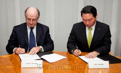 SK Group chairman Chey Tae-won (right) and Repsol chairman Antonio Brufau Niubo sign the letter of intent to collaborate on the lubricant base oil plant in Madrid on Friday.  SK Group