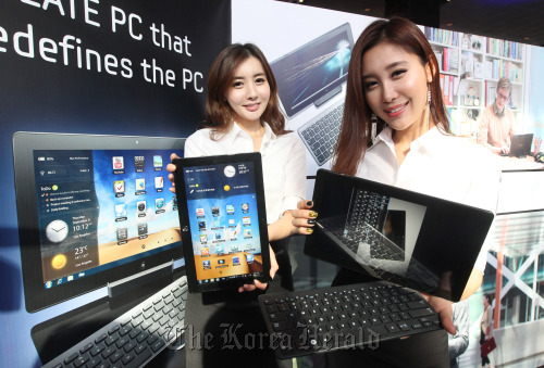 Models pose with new Samsung Slate PC Series 7 at a launching ceremony in Seoul on Wednesday. The new personal laptop, armed with new technologies used in tablet PC, is significantly lighter and slimmer than previous models.	 Yonhap News