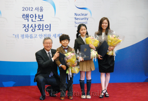 Foreign Minister Kim Sung-hwan (left) and honorary ambassadors for the 2012 Nuclear Security Forum in Seoul, including singer Park Jung-hyun (right) pose for a photo after an appointment ceremony on Thursday. Foreign Ministry
