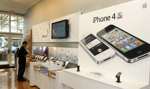 An advertisment for the Apple Inc. iPhone 4S is displayed at a Sprint Nextel Corp. store in Palo Alto, California, U.S. (Bloomberg)