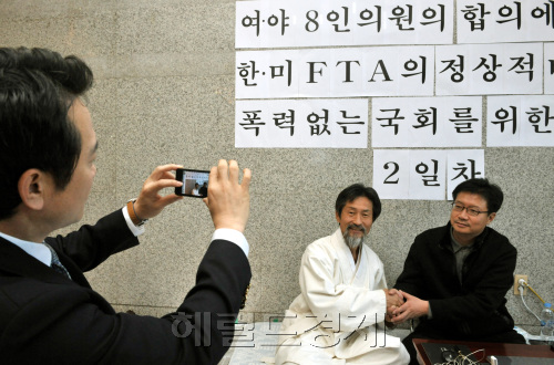 한미 FTA 비준안에 대한 여야 합의 처리 등을 촉구하며 이틀째 단식농성중인 한나라당 정태근(오른쪽)  의원이 14일 오전 의원회관에서 농성장에서 민주노동당 강기갑 의원과 만나는 모습을 남경필 외통위원장이 자신의 트위터에 올리겠다고 휴대폰으로 촬영을 하고 있다.양동출dcyang@heraldm.com/111114/\r\n한미 FTA 비준안에 대한 여야 합의 처리 등을 촉구하며 이틀째 단식농성중인 한나라당 정태근(오른쪽)  의원이 14일 오전 의원회관에서 농성장에서 민주노동당 강기갑 의원과 만나는 모습을 남경필 외통위원장이 자신의 트위터에 올리겠다고 휴대폰으로 촬영을 하고 있다.양동출dcyang@heraldm.com/111114/