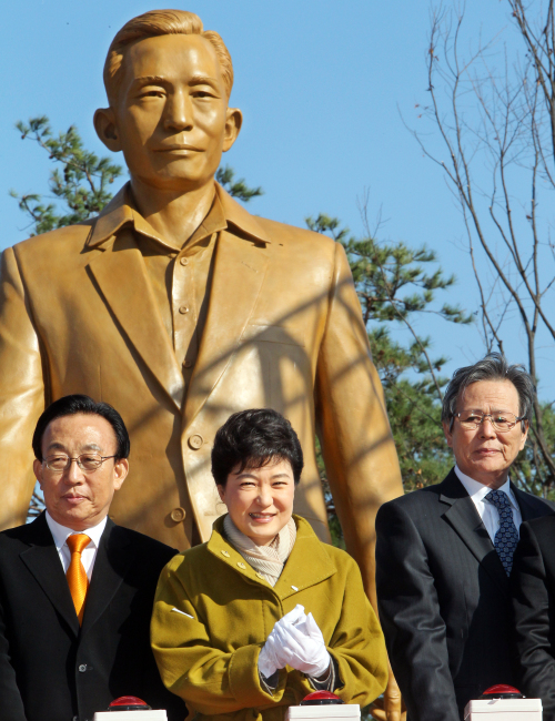 Rep. Park Geun-hye (center) of the ruling Grand National Party stands in front of the statue of her father,
the late President Park Chung-hee, near his birthplace in Gumi, North Gyeongsang Province, Monday. The statue was unveiled
in a ceremony marking his birth on Nov. 14. (Yonhap News)