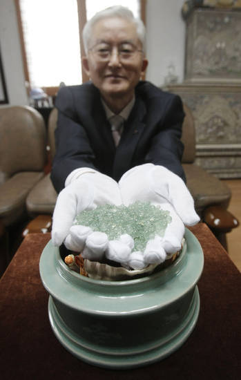 Kim Il-nam, a retired high school principal, displays beads made from his father’s ashes during an interview in Icheon, Gyeonggi Province, on Oct 12.     AP-Yonhap News