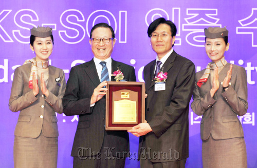 Asiana Airlines chief executive Yoon Young-doo (second from left) and KSA chief Kim Chang-ryong (third from left) pose with the plaque the air carrier was given for topping a service quality survey on Thursday at a Seoul hotel.  Asiana Airlines