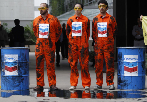 <YONHAP PHOTO-1934> Greenpeace activists protest using simulated oil to protest an oil spill in an offshore field operated by Chevron Corp, outside Chevron's offices in Rio de Janeiro, Brazil, Friday Nov. 18, 2011. The Brazilian Federal Police on Thursday began investigating an oil spill in an offshore field operated by Chevron Corp., a leak that an environmental group alleges is far bigger than the company has stated. The leaking well is part of the Chevron-operated Frade project, located underwater off the northeastern coast of Rio de Janeiro state. (AP Photo/Silvia Izquierdo)/2011-11-18 22:21:14/ <저작권자 ⓒ 1980-2011 ㈜연합뉴스. 무단 전재 재배포 금지.>
Greenpeace activists protest using fake oil to protest an oil spill in an offshore field operated by Chevron Corp, outside Chevron’s offices in Rio de Janeiro, Brazil, Friday.  AP-Yonhap News