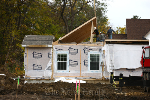 Workers lift the roof of a Champion Home Builders Inc. sectional home in Flint, Michigan.  Bloomberg