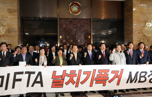 Opposition lawmakers hold a rally at the National Assembly on Wednesday to protest the ruling party’s railroading of the Korea-U.S. Free Trade Agreement the previous day.  (Yonhap News)