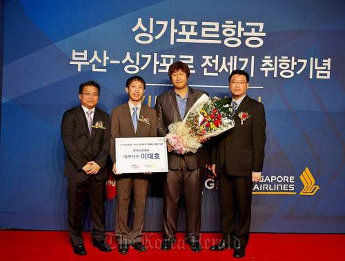 Singapore Airlines’s regional vice president Lim Wee Kok (far left) poses with officials after appointing former Lotte Giants slugger Lee Dae-ho (second from right) as a goodwill ambassador at a ceremony on Wednesday in Busan.   Singapore Airlines