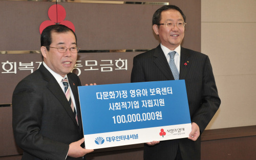 Daewoo International Corp.’s senior managing director Shin Young-kwon (left) poses with Community Chest of Korea secretary general Park Sung-joong after donating 100 million won ($86,300) to support social enterprises on Thursday in Seoul. (Chung Hee-cho/The Korea Herald)