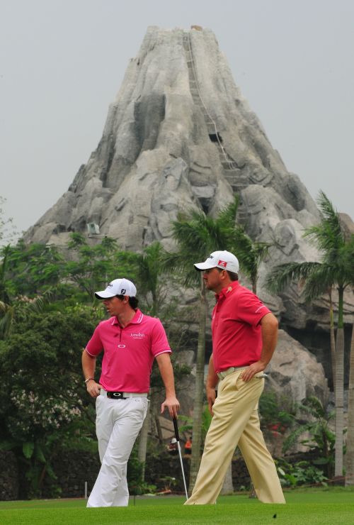 Ireland’s Rory McIlroy (left) and Graeme McDowell line up a putt during the first day of 56th World Cup golf at the Mission Hills golf course in Haikou, China, Thursday. (AFP-Yonhap News)