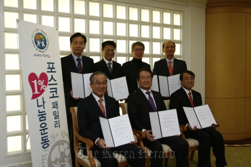 (Counterclockwise from front left) POSCO’s outside directors ― vice chairman of Samchully Co. Han Joon-ho, honorary professor at Ewha Womans University Yoo Jang-hee, Hallym University president Lee Young-sun, former vice president of LG Electronics Nam Yong, president of Humax Co. Byun Dae-gyu, Seoul National University professor Lee Chang-hee and lawyer Park Sang-gil ― pose after signing an agreement to donate 1 percent of their paychecks. POSCO