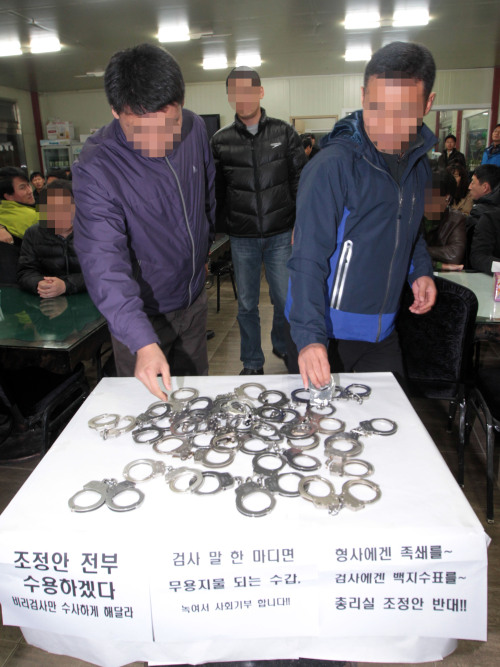 Police officers turn in handcuffs on Friday. (Yonhap News)