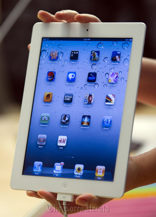 An Apple employee holds the iPad 2 at the Apple Inc. flagship retail store in New York.   Bloomberg