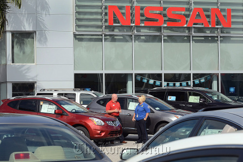 Sales associate Bob Stevens (left) helps customer Christie LaVoie shop for a 2012 Nissan Motor Co. Rogue vehicle at Royal Palm Nissan car dealership in Royal Palm Beach, Florida.  Bloomberg