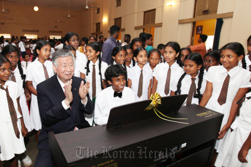 Booyoung Group chairman Lee Joong-keun (second from left, front row) claps as children sing at a graduation ceremony held by the company for elementary school students on Dec. 2 in Colombo, Sri Lanka’s capital.     Booyoung Group
